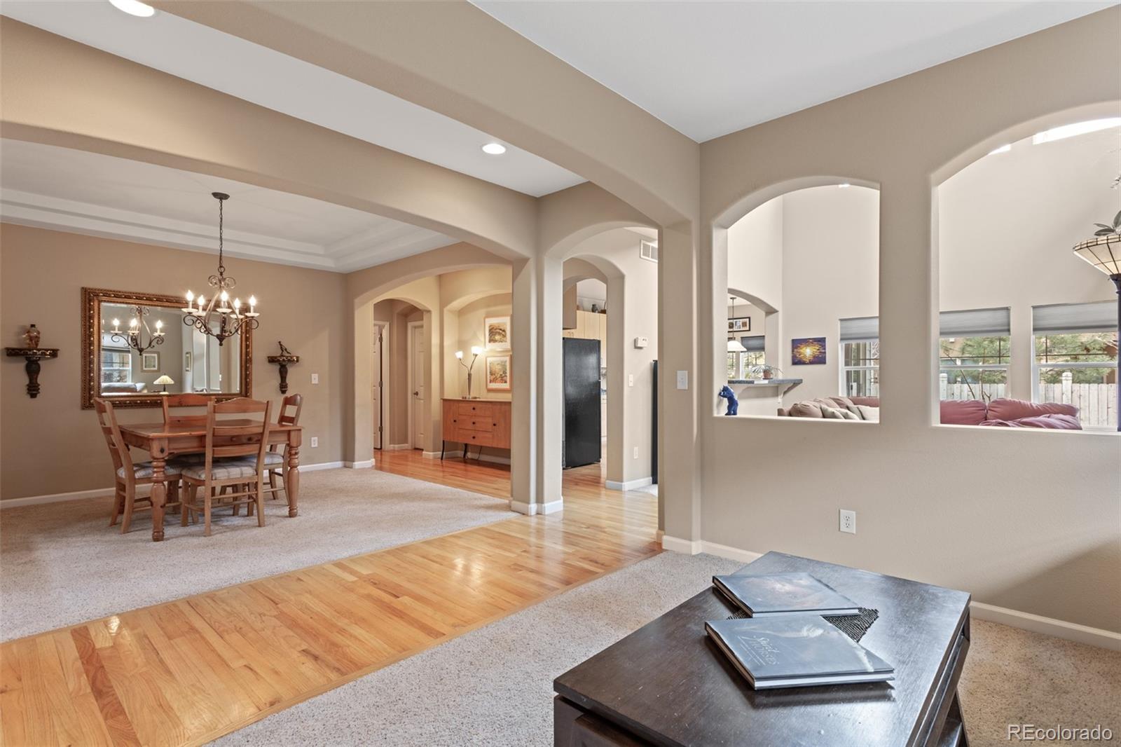 4207 Frederick Circle Longmont, CO 80503 - Photo 4 of 35 a living room with furniture a window and a dining table with wooden floor