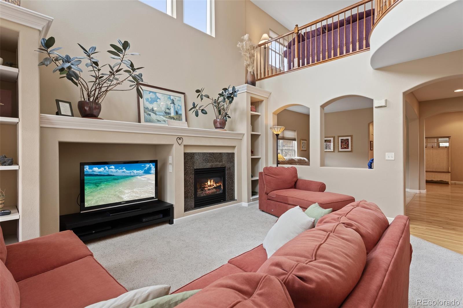 4207 Frederick Circle Longmont, CO 80503 - Photo 8 of 35 a living room with furniture a fireplace and a flat screen tv