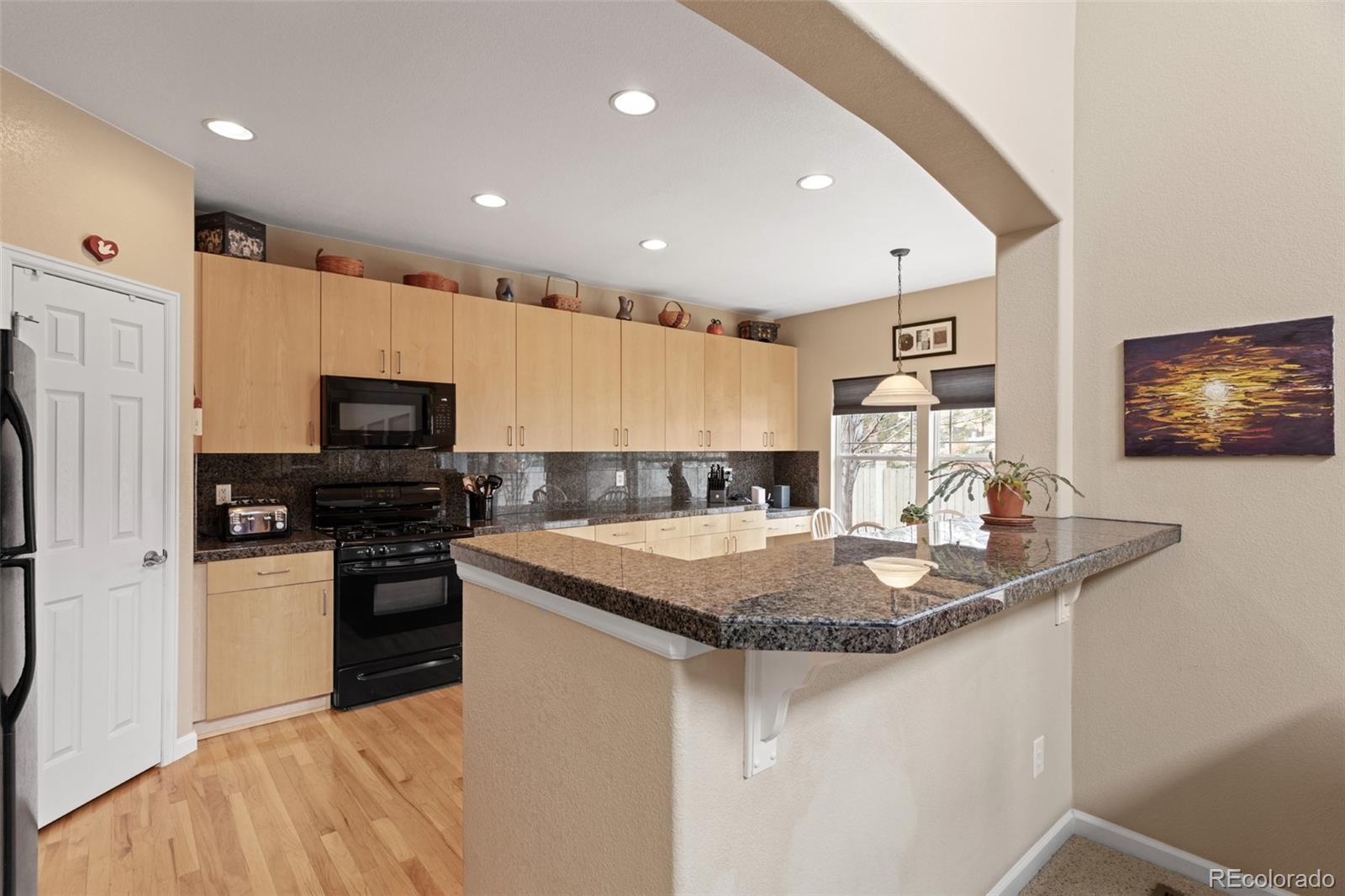 4207 Frederick Circle Longmont, CO 80503 - Photo 9 of 35 a kitchen with stainless steel appliances granite countertop a sink a stove and a refrigerator