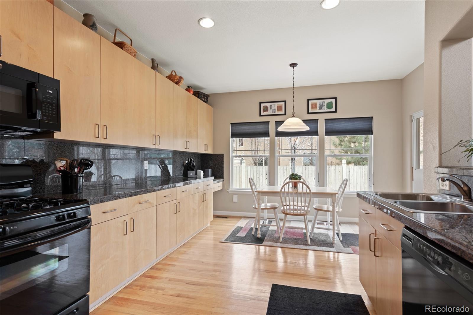 4207 Frederick Circle Longmont, CO 80503 - Photo 10 of 35 a very nice looking kitchen with granite countertop a stove top oven a sink a counter space and cabinets