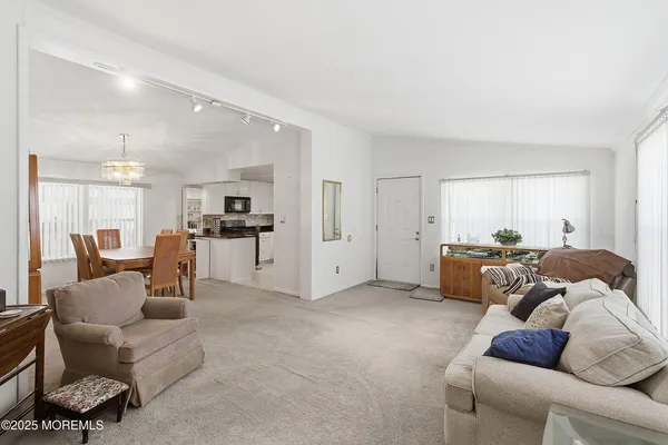 a living room with furniture and a dining table with kitchen view