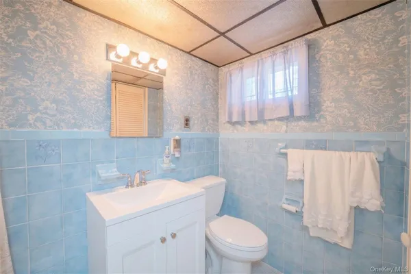 a bathroom with a sink a toilet and mirror