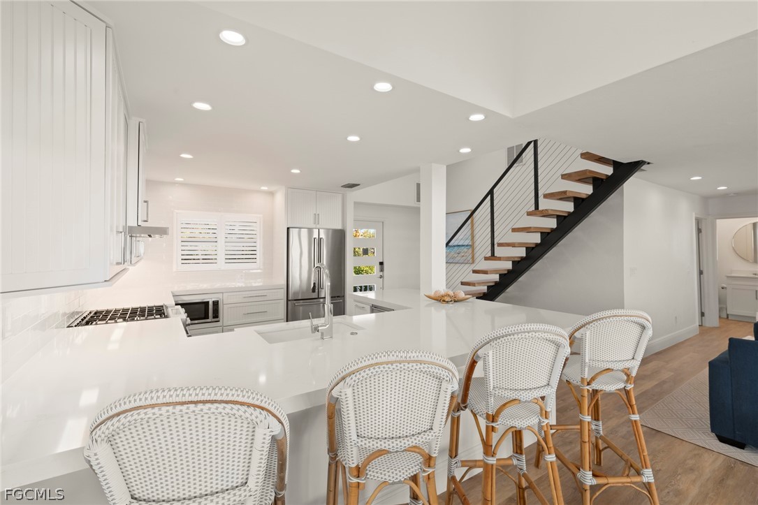 19 Beach Homes Captiva, FL 33924 - Photo 16 of 49 a kitchen with stainless steel appliances kitchen island granite countertop a dining table chairs and sink