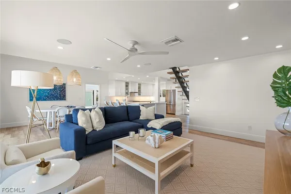 a living room with furniture a rug and kitchen view