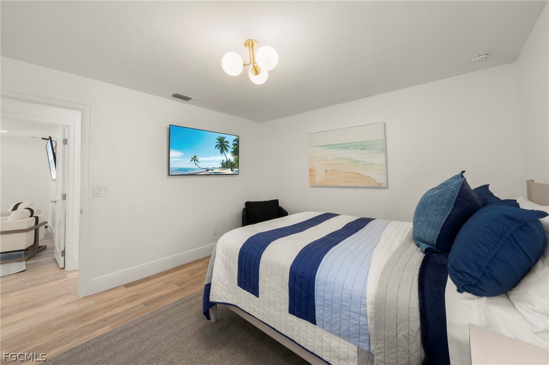 19 Beach Homes Captiva, FL 33924 - Photo 32 of 49 a bedroom with a bed and a chandelier