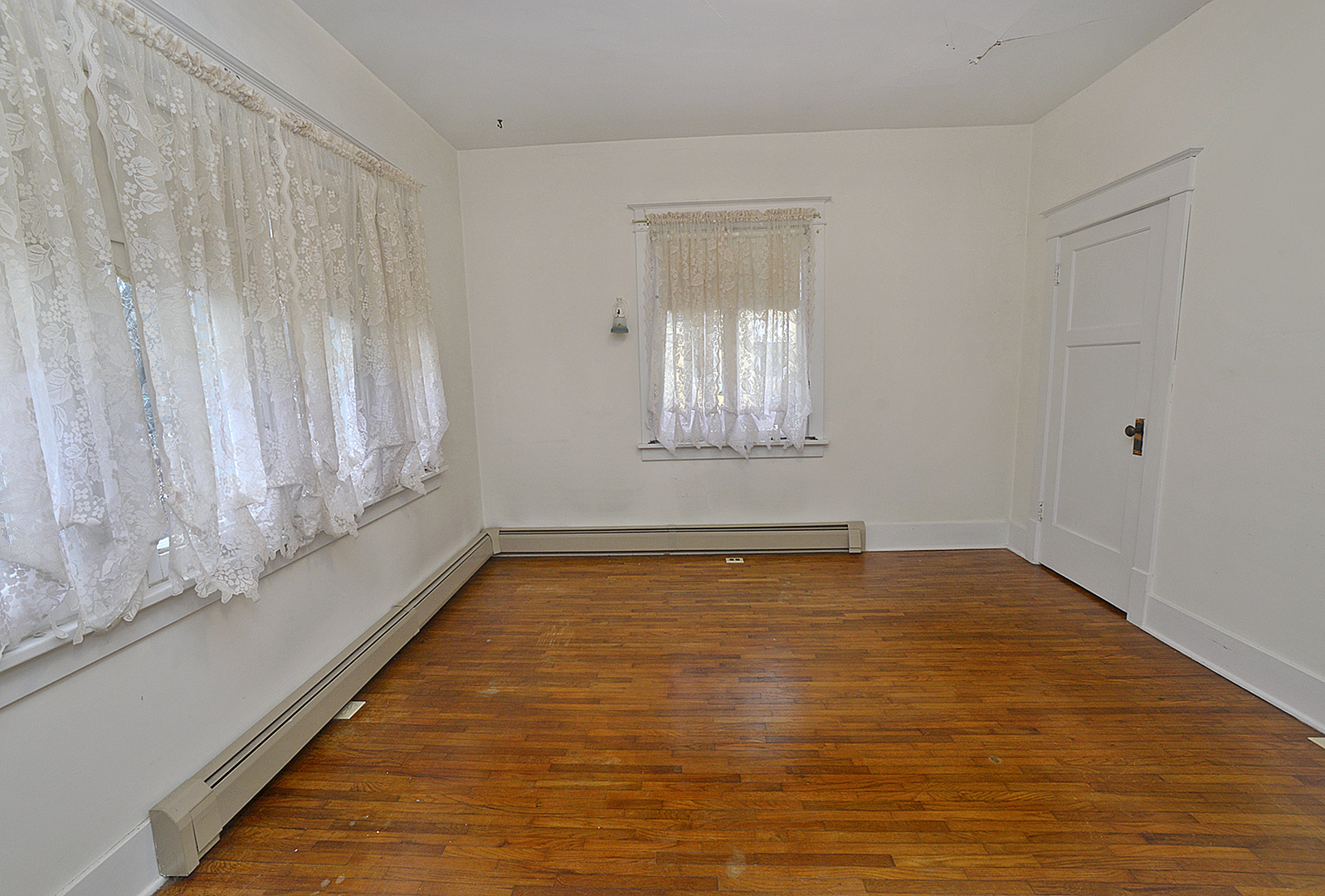 221 East Grove Street Utica, IL 61373 - Photo 14 of 27 a view of an empty room with window and wooden floor