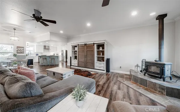 a kitchen with stainless steel appliances granite countertop a sink a stove a refrigerator with white cabinets and wooden floor