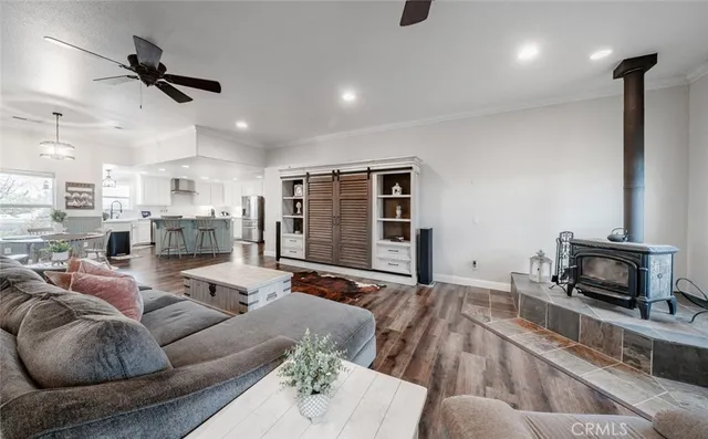 a kitchen with stainless steel appliances granite countertop a sink a stove a refrigerator with white cabinets and wooden floor