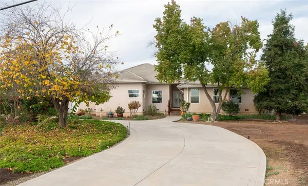 a front view of a house with a yard and trees