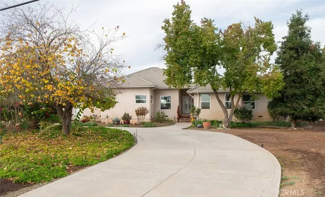 a front view of a house with a yard and trees