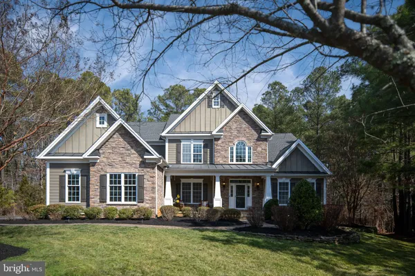 a living room with stainless steel appliances furniture wooden floor and a rug
