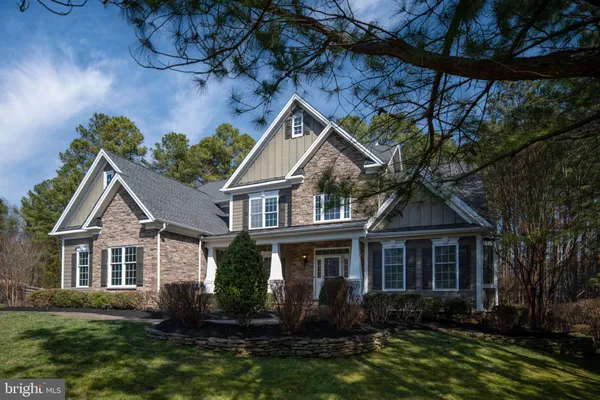 a kitchen with stainless steel appliances granite countertop a refrigerator a stove top oven a sink and dishwasher with wooden floor