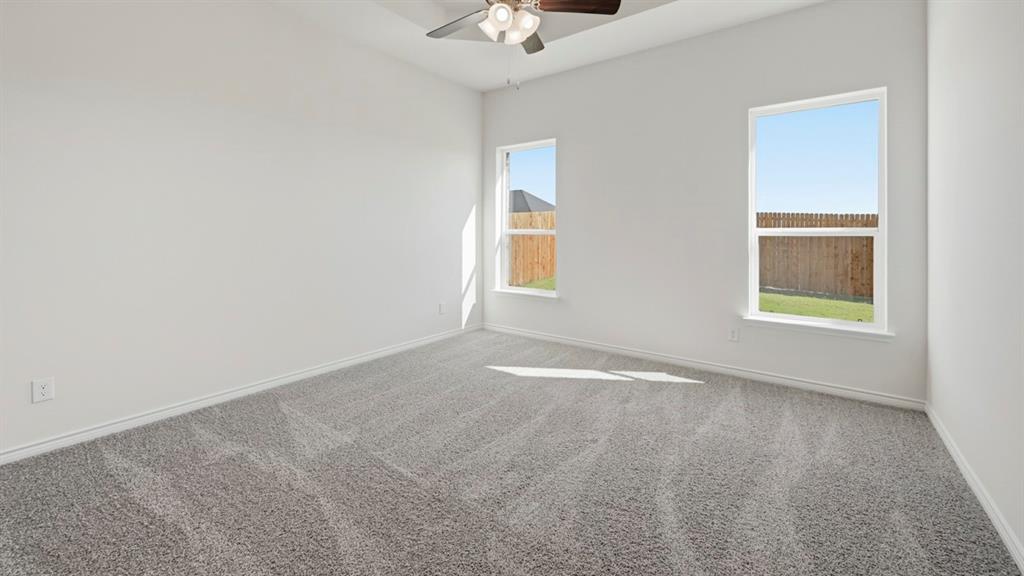 4163 Waldron Trail Forney, TX 75126 - Photo 25 of 30 Room featuring light gray carpeting, two windows, a ceiling fan, and white painted walls