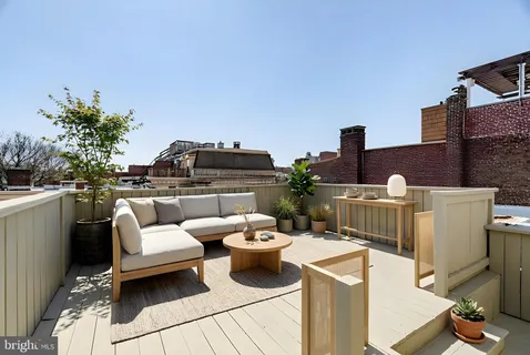 a living room with a couch and potted plants on the table