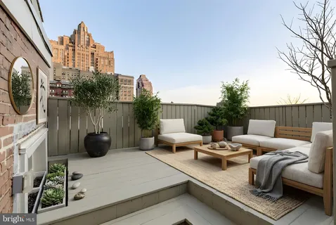 a view of a roof deck with couches and potted plants
