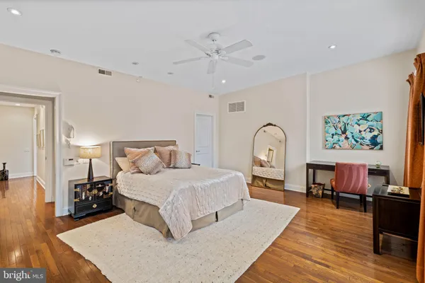 a bedroom with a bed large window and a dresser