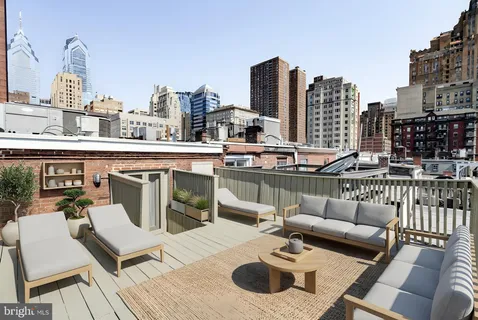 a view of a patio with couches table and chairs and wooden floor