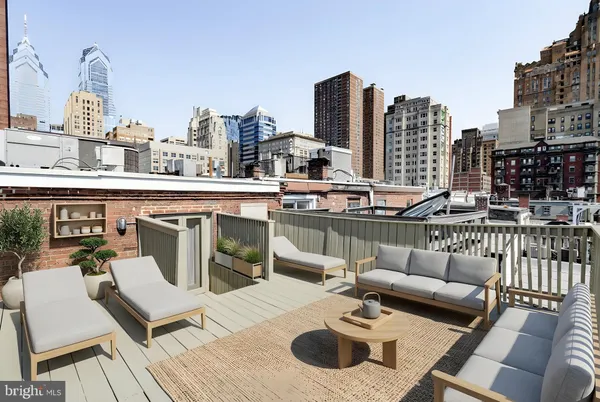 a view of a patio with couches table and chairs and wooden floor