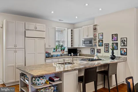 a kitchen with stainless steel appliances granite countertop a sink and a refrigerator