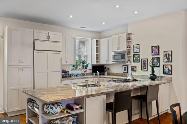 a kitchen with stainless steel appliances granite countertop a sink and a refrigerator