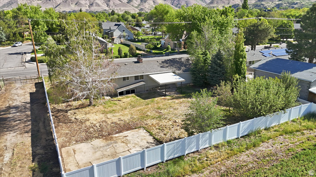 810 East Maple Street Mapleton, UT 84664 - Photo 35 of 49 Spacious property featuring a large backyard with mature trees, a white vinyl perimeter fence, and a concrete pad