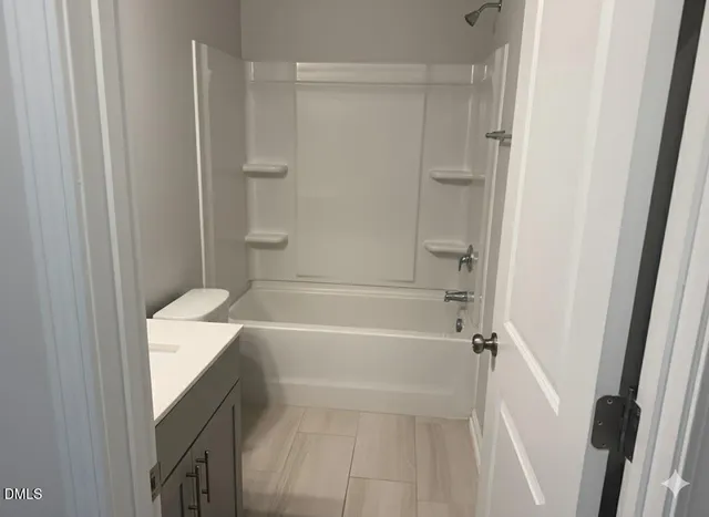 a bathroom with a tub shower vanity and a sink