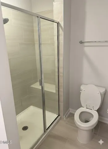 a bathroom with a toilet and a shower