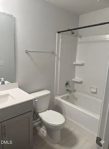 a white toilet sitting next to a bath tub