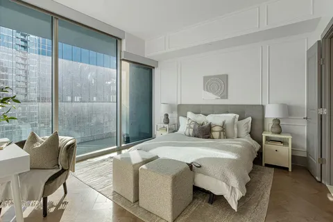 a spacious bedroom with a bed and glass door