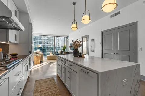 a kitchen with stainless steel appliances granite countertop a sink a stove and a wooden floors