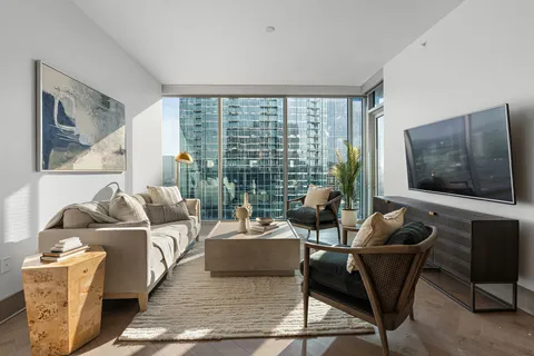 a living room with furniture and a floor to ceiling window