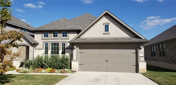 a front view of a house with a yard garage and outdoor seating