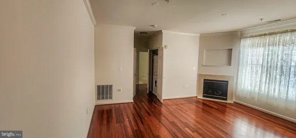 a view of empty room with wooden floor and fireplace