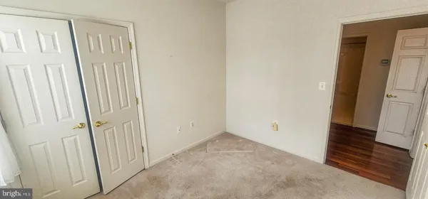 an empty room with a ceiling fan and carpet