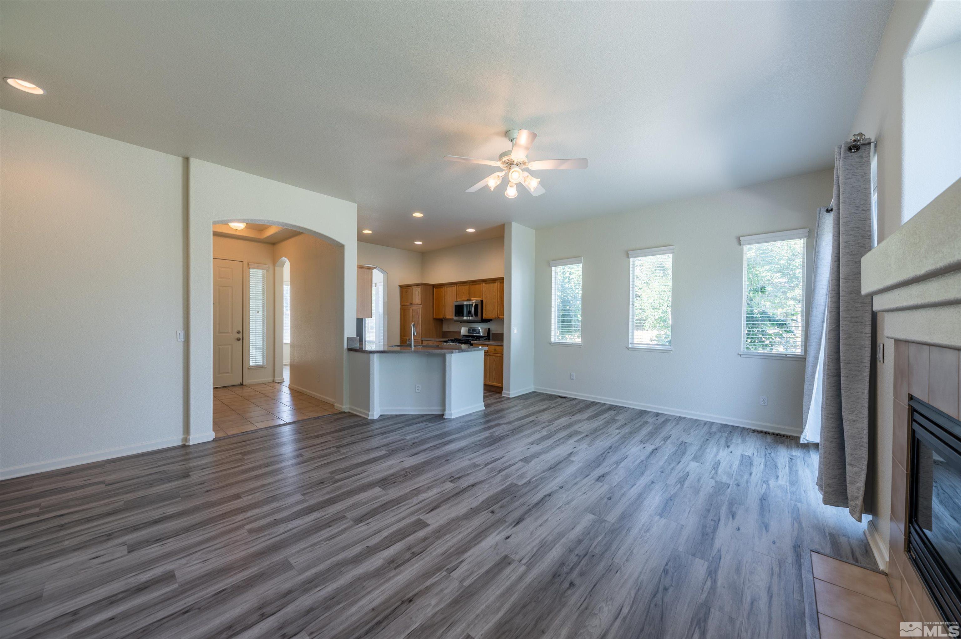 1462 Wessex Circle Reno, NV 89503 - Photo 7 of 40 an empty room with wooden floor and a kitchen