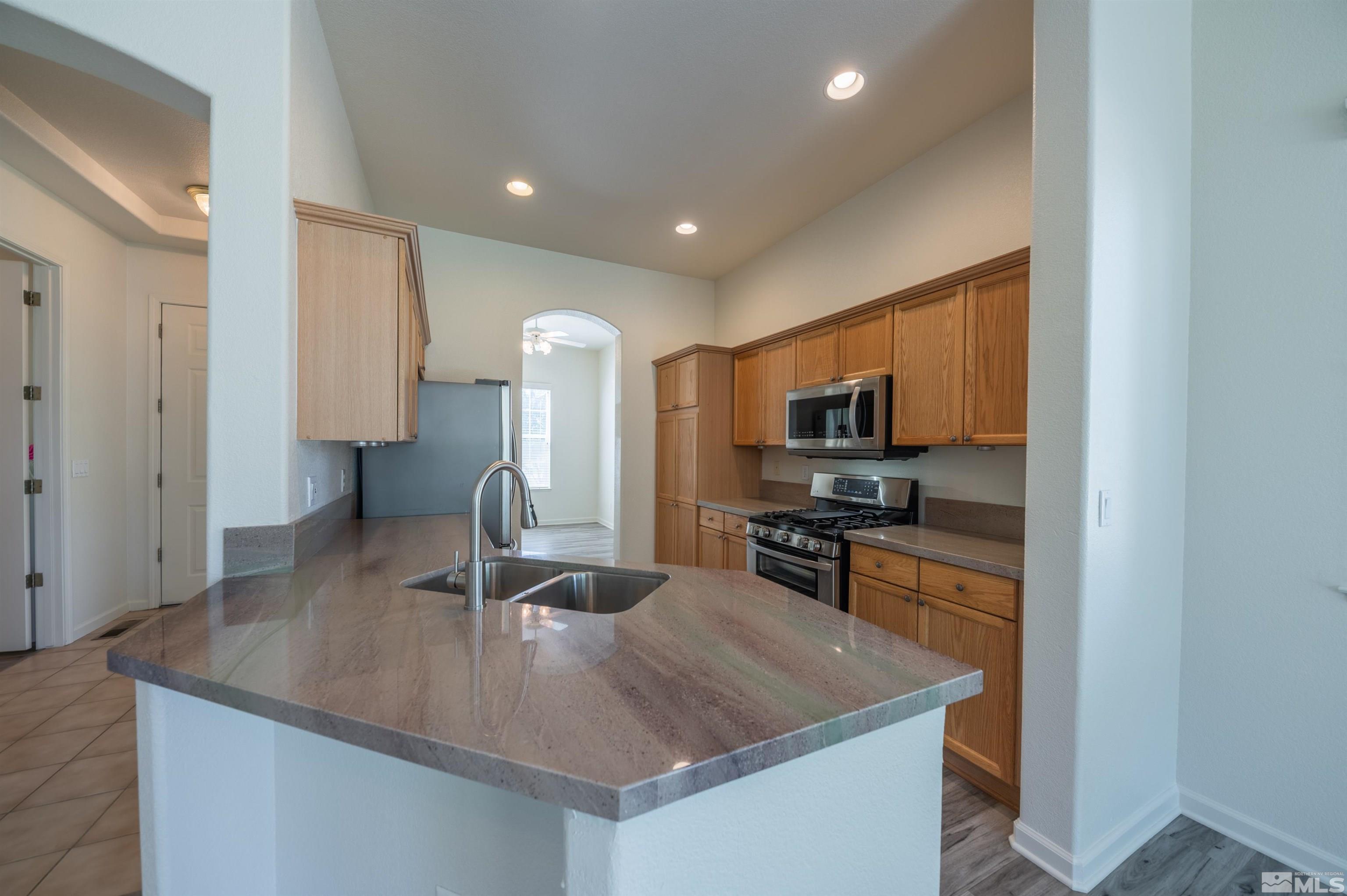 1462 Wessex Circle Reno, NV 89503 - Photo 9 of 40 a kitchen with stainless steel appliances granite countertop a sink refrigerator and microwave