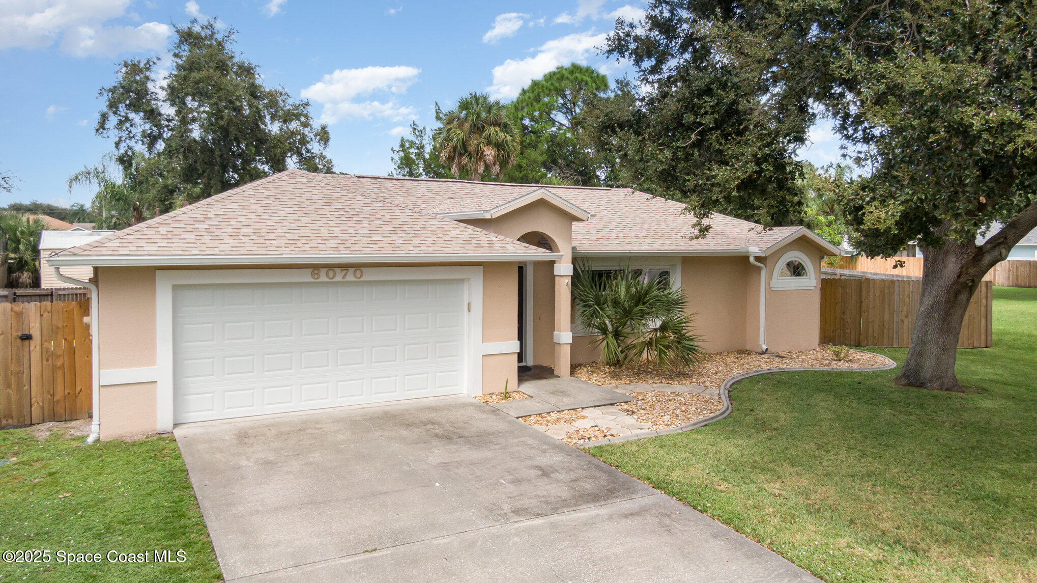 a view of a house with a yard and large tree