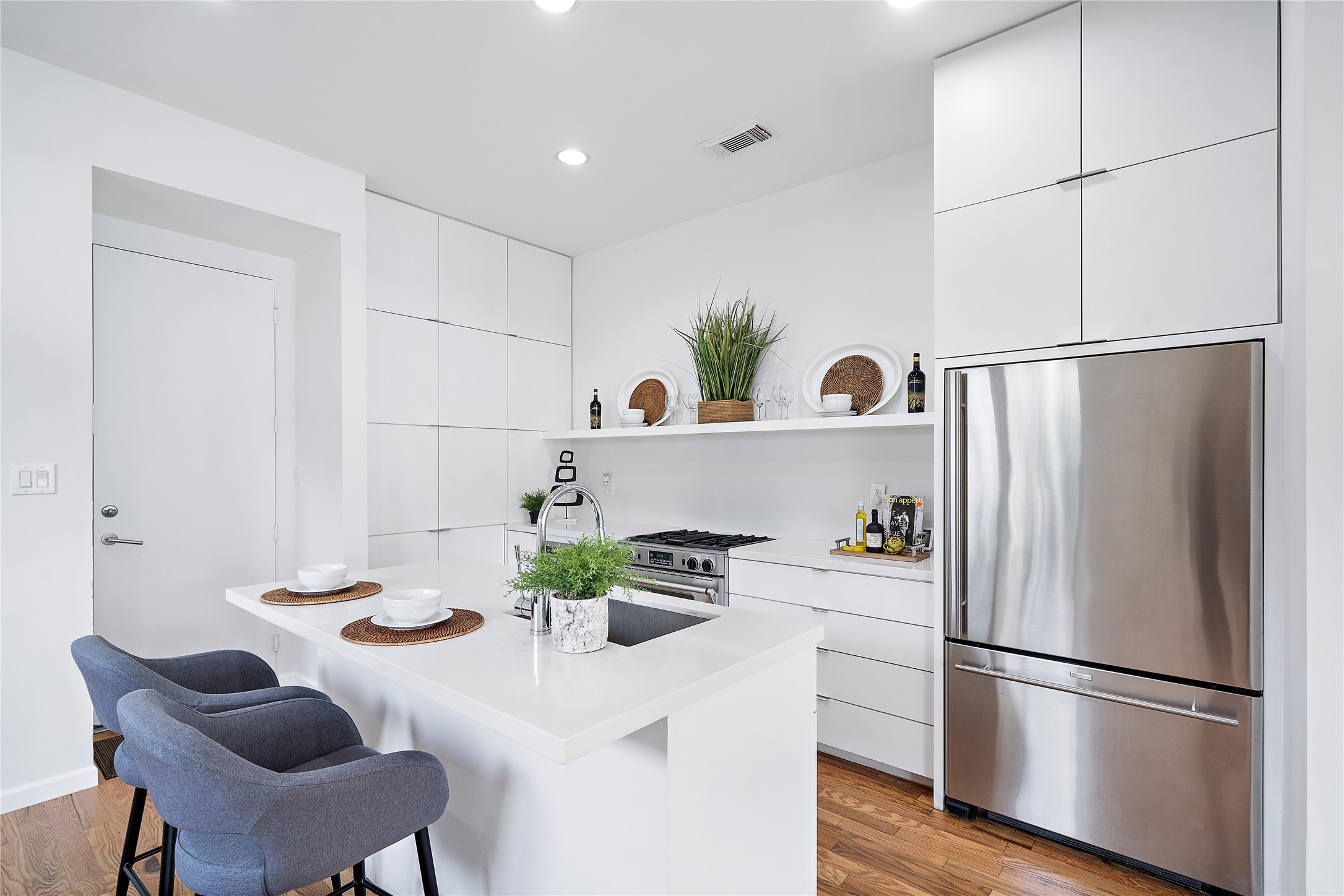 2437 North Boulevard Houston, TX 77098 - Photo 6 of 32 a kitchen with a refrigerator and white cabinets