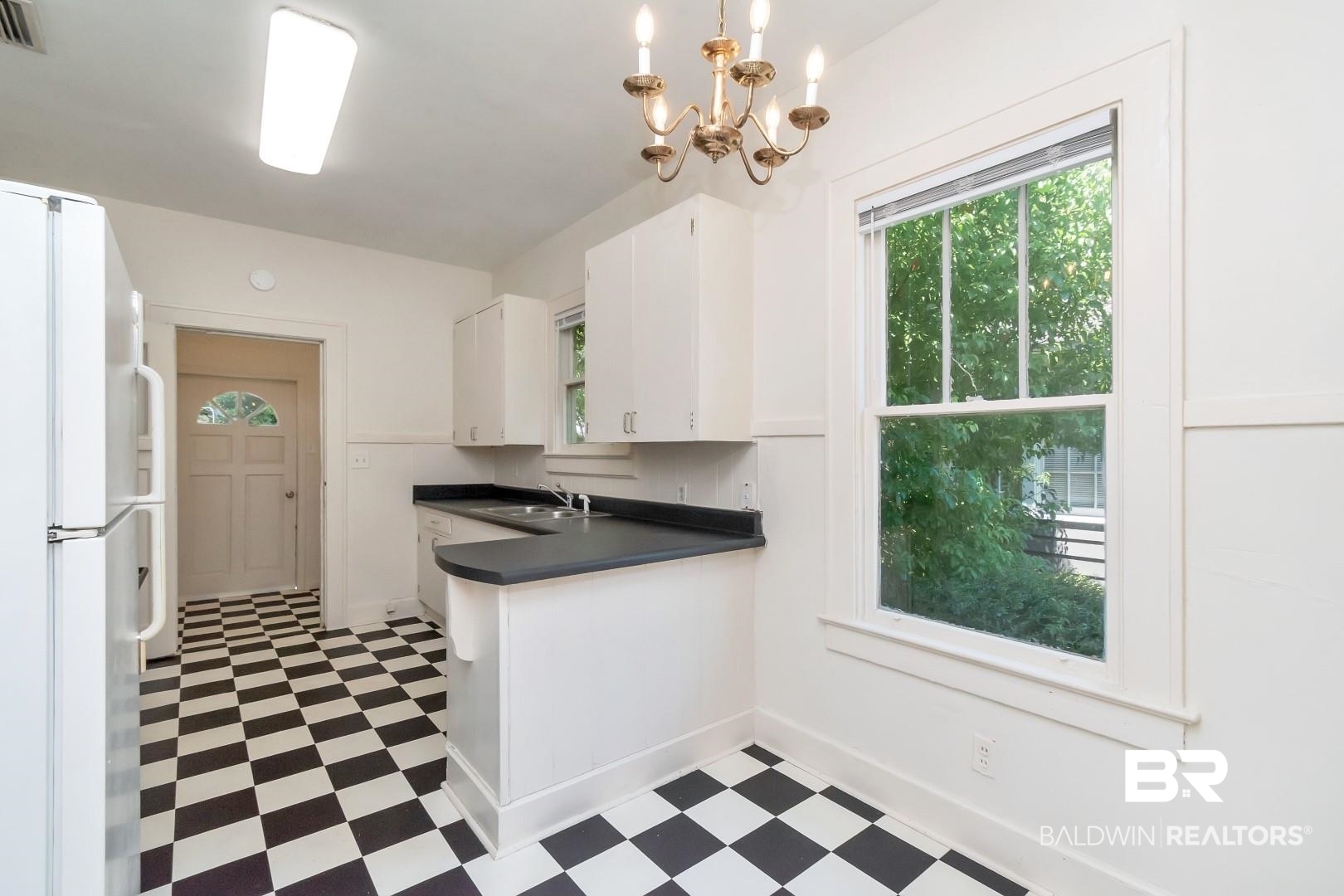 112 South Fulton Street Mobile, AL 36606 - Photo 15 of 35 Kitchen with white cabinetry, a chandelier, sink, hanging light fixtures, and white refrigerator
