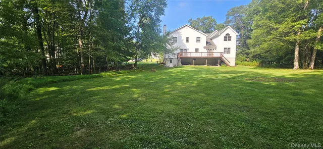 a front view of a house with a yard and trees
