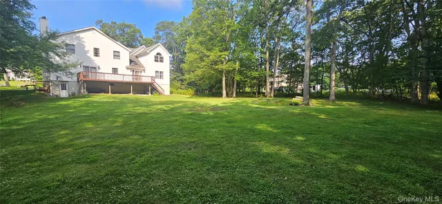 a view of a house with a yard and a tree