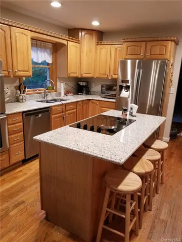 a kitchen with granite countertop a sink a counter top space and stainless steel appliances