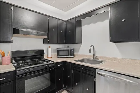 a kitchen with a sink stove and cabinets