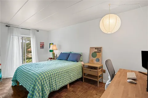 a bedroom with a bed chair and a window