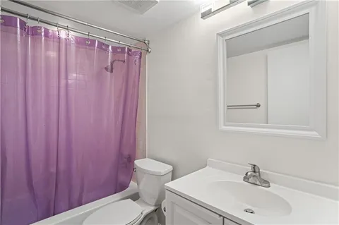 a bathroom with a sink a toilet and shower curtain