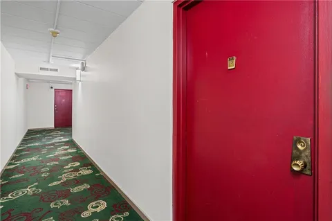 a view of a livingroom with a red wall & staircase