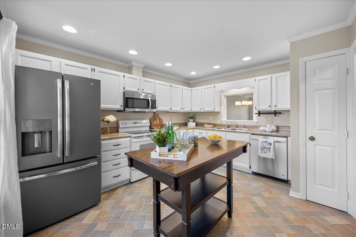 1511 Hemphill Drive Raleigh, NC 27609 - Photo 6 of 37 a kitchen with a refrigerator a sink and chairs