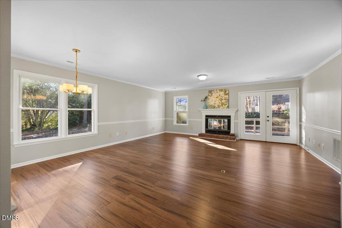 1511 Hemphill Drive Raleigh, NC 27609 - Photo 8 of 37 a view of an empty room with wooden floor and a window
