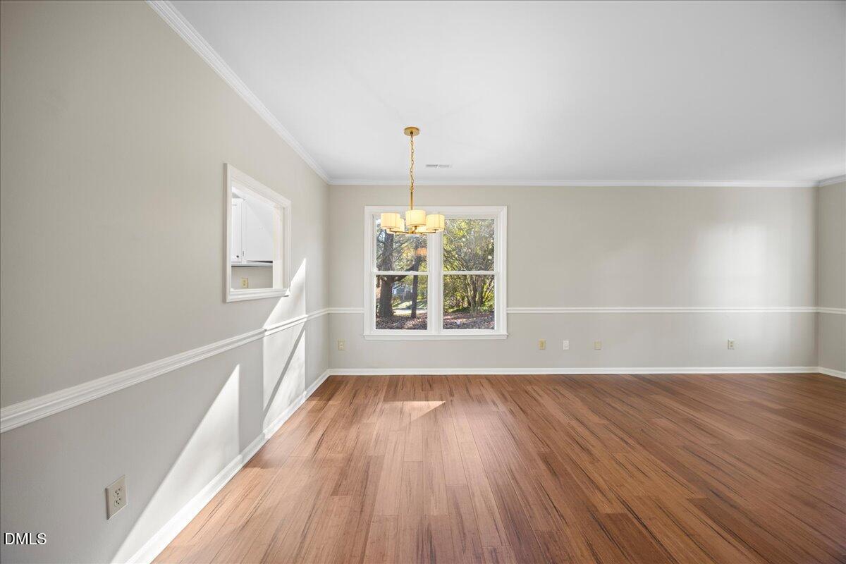 1511 Hemphill Drive Raleigh, NC 27609 - Photo 9 of 37 an empty room with wooden floor and windows