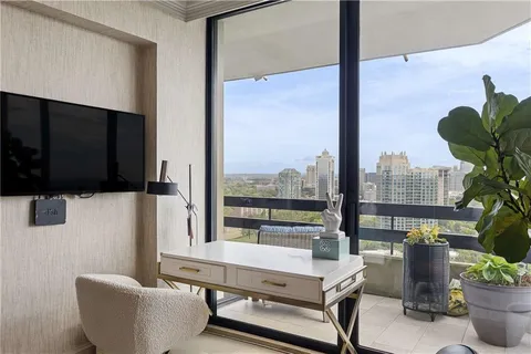 a living room with furniture and a floor to ceiling window